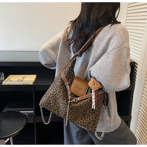 Detail of leopard print tote bag with brown faux leather flap and cute bear pendant charm