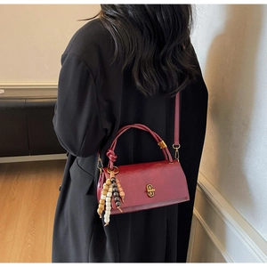Retro red rectangular handbag with gold oval lock and three-color wooden bead pendant