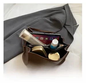 Internal view of brown leather backpack showing spacious storage for tablet and cosmetics