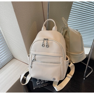 Close-up of cream white lychee texture backpack with dual ring silver metal zippers
