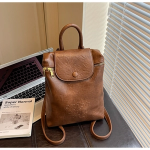 Détail du sac à dos vintage en cuir marron avec rabat magnétique et zip doré brillant