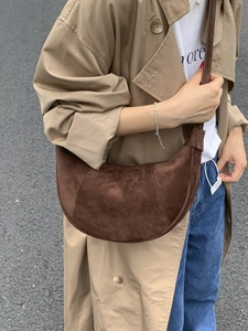 Classic dark brown suede crescent crossbody bag worn with khaki trench coat in street style