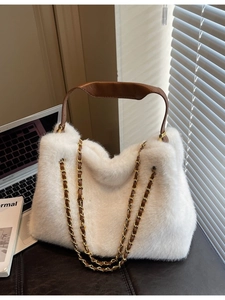 White fluffy faux fur tote bag with brown leather handle and gold chain straps