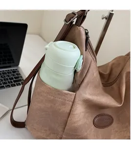Detailed view of the brown canvas backpack side pocket holding a green water bottle