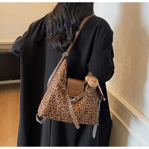 Close-up of leopard print hobo bag featuring brown leather trim and cute bear charm