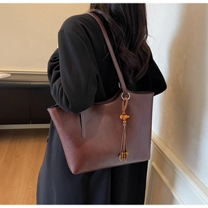 Detail of vintage large tote bag with wooden bead tassel charm on shoulder strap