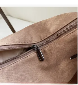 Close-up of smooth nylon zipper and metal puller on the brown fabric backpack detail