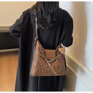 Detail of leopard print tote bag with brown leather flap and cute bear plush charm