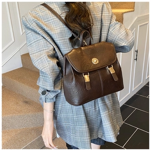 Detailed back view of a retro dark brown leather backpack with golden twist lock closure