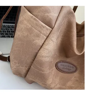 Close-up of brown tote bag canvas texture with precision stitching and brand logo patch