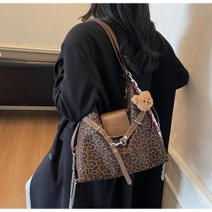 Detail of leopard print tote bag with leather flap and cute bear pendant on model