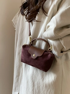 Chic burgundy faux suede crossbody bag with contrast brown leather flap and gold hardware