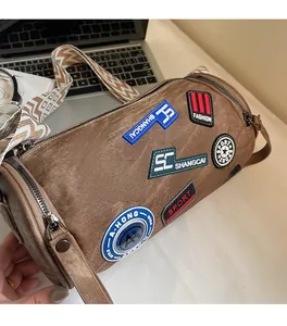 Dettaglio borsa a cilindro retrò con badge alla moda e tracolla in tessuto a righe