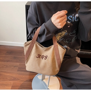Detailed shot of a vintage canvas tote bag in khaki with RQG embroidery and fabric handles