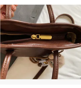 Vista dettagliata della borsa vintage in pelle marrone con cerniera in metallo bronzo