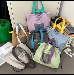 Detail of multi-color tote bags with mesh pockets and adjustable drawstrings