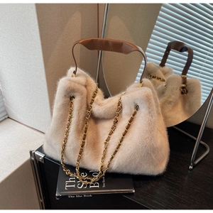Detail of plush faux fur tote bag in beige with brown leather handle and chain strap