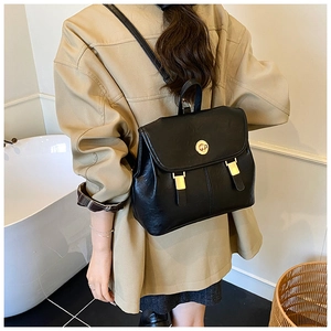 Detail of premium black leather texture and gold twist lock on the retro backpack