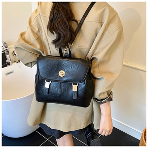 Detail view of the black vintage leather backpack with gold twist-lock and metal hardware