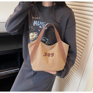Detailed shot of durable khaki canvas tote bag featuring premium XQ9 letter embroidery