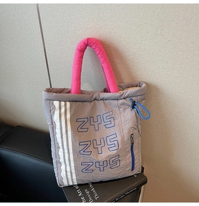 Quilted tote bag with grey body, pink handles and blue side pocket for casual style