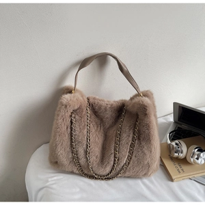 Detail of soft camel faux fur tote bag with leather handle and metal chain shoulder strap