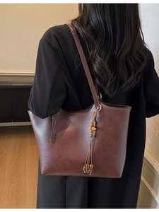 Retro dark brown large tote bag with vintage bead tassel seen on model in warm room