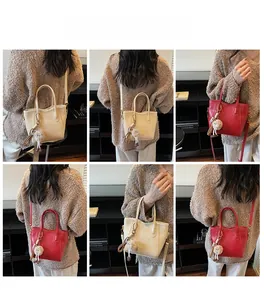 Vista dettagliata della borsa a secchiello vintage in beige e rosso con charm