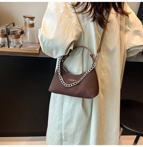 Détail du sac croissant en daim marron café avec chaîne argentée et texte mode