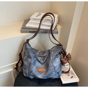 Blue washed denim tote bag with brown leather straps and charming heart bow pendants