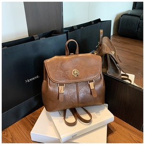 Detail of vintage brown leather backpack with metallic twist lock and retro buckle