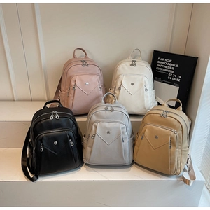 Detailed collection of minimalist leather backpacks in five pastel colors on steps