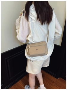Khaki Multi-Taschen Nylon Umhängetasche an Model in modernem Innenraum getragen