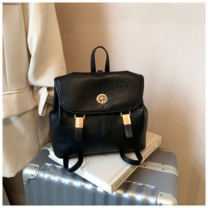 Detail of vintage black leather backpack showing the elegant gold swivel lock and metal hardware