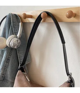 Détail du sac fourre-tout en daim marron avec bandoulière en cuir noir et zip argenté
