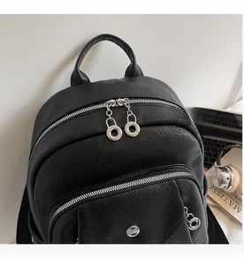 Detailed macro view of smooth silver zippers and textured leather on a black backpack