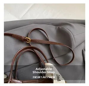 Détail d'un sac seau en cuir marron avec bandoulière réglable et finitions dorées