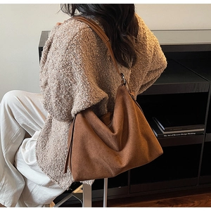 Sac cabas marron en cuir mat porté par un mannequin en cardigan en maille douce