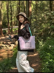 Close-up of lilac tote bag featuring a front mesh pocket and mint green straps in forest