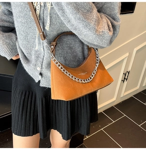 Détail du sac lune en daim marron avec bandoulière chaîne argentée et cuir souple