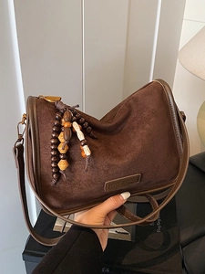 Dark brown suede dumpling shoulder bag with wood bead tassel and leather logo patch