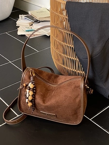 Brown frosted leather crossbody bag with wooden bead tassel and adjustable strap
