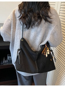 Große schwarze Wildleder-Hobo-Tasche mit weißen Kontrastnähten und Perlenanhänger-Detail