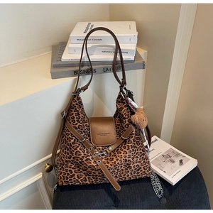 Detail of leopard print tote bag with brown leather flap and cute plush bear charm