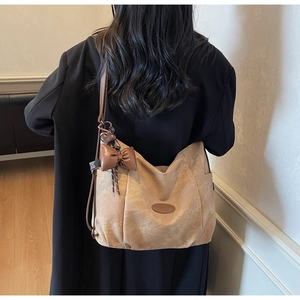 Detail of khaki large tote bag with brown ribbon bow and adjustable shoulder strap