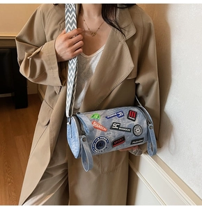 Borsa a cilindro in denim con toppe colorate e tracolla a zigzag indossata con cappotto