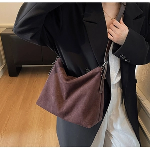 Détail du sac cabas en daim marron foncé avec bandoulière en cuir et boucles argentées