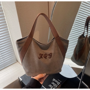 Detailed embroidery on durable canvas tote bag with stylish webbing handle design