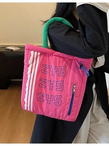 Quilted nylon tote bag in vibrant magenta with green handles for winter fashion