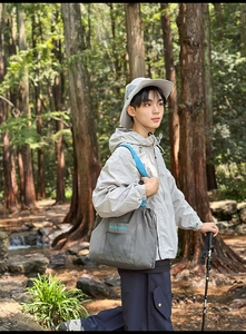 Close-up of durable grey nylon tote bag with blue straps in a forest hiking scene